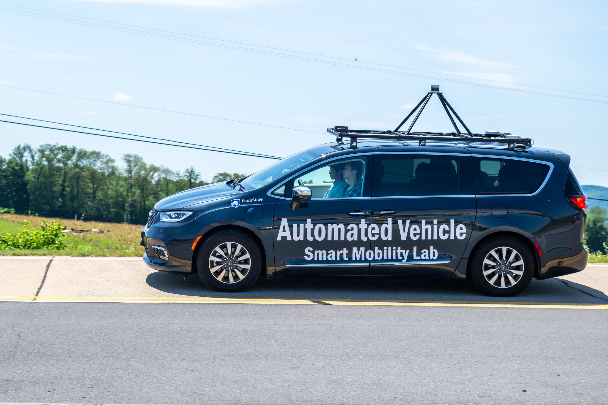 The Smart Mobility Lab’s automated vehicle, a wrapped Chrysler Pacifica with a roof sensor rack, driving on the LTI test track