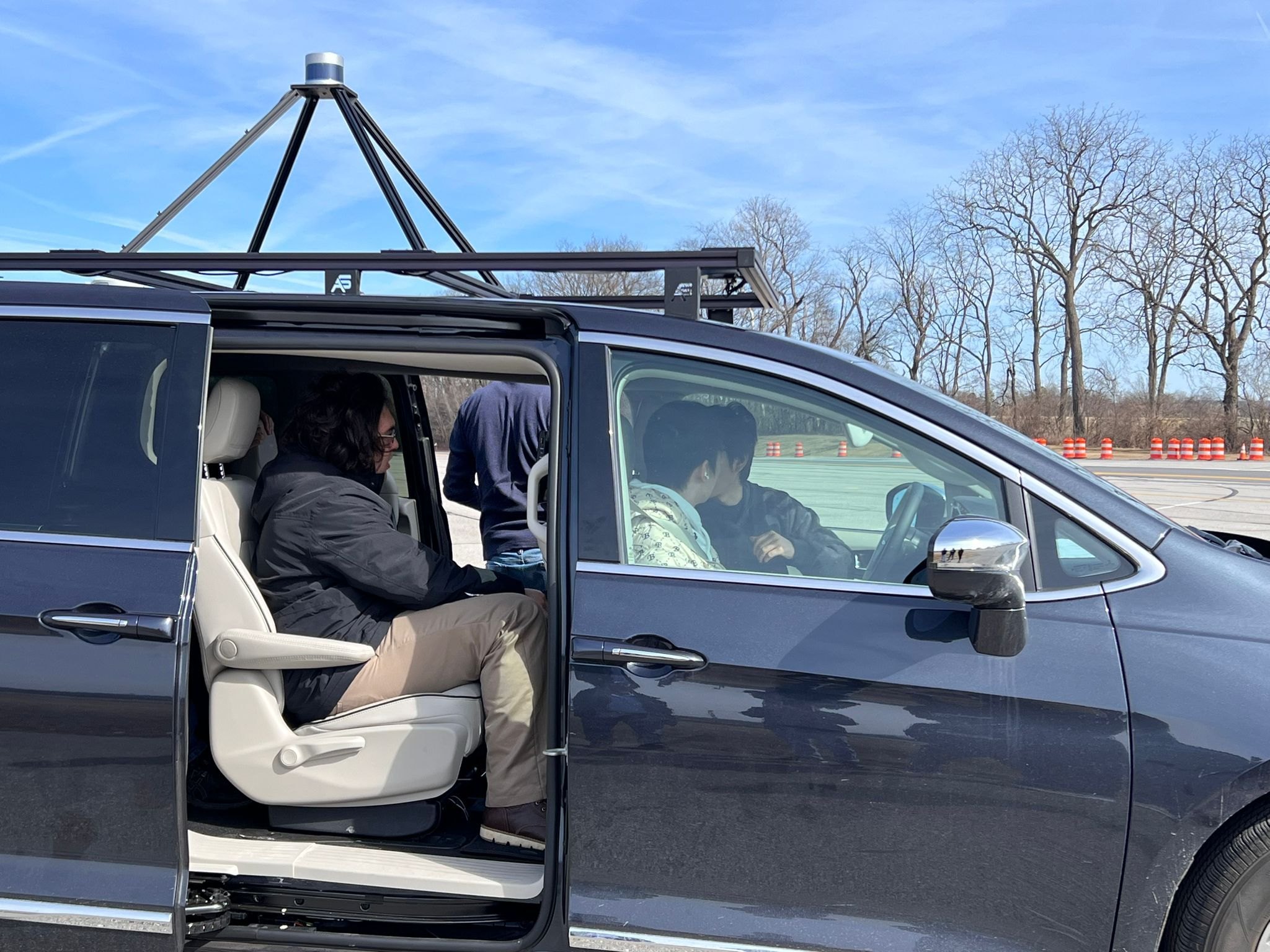 Students seated in the lab’s automated vehicle, a Chrysler Pacifica with a roof sensor rack